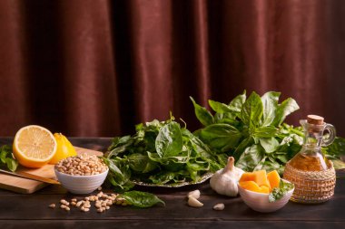 Evde pesto sosu yapma süreci. Kadın sos yapmak için havana fesleğen yapraklı zeytinyağı döküyor..