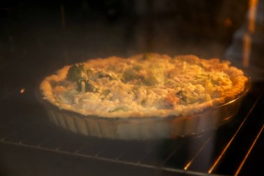 Peynir serpilmiş, fırında pişirilmiş tavuk ve brokoli ile açık kurabiye turtası.