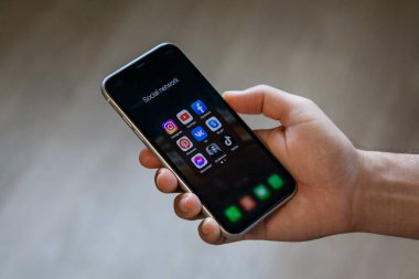 Adam elinde sosyal ağların ve kuryelerin simgeleriyle akıllı telefon tutuyor. Instagram, TikTok, Youtube, Facebook, Pinterest, VK, Skype, Messenger, Club. Rostov-on-Don, Rusya, 31 Ağustos 2021.