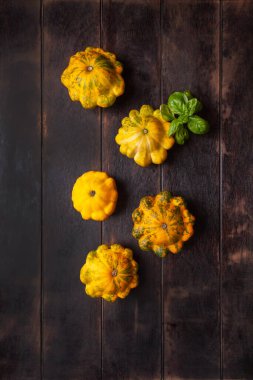 Sarı pastalar ya da kabak ve kahverengi ahşap arka planda fesleğen yaprağı..
