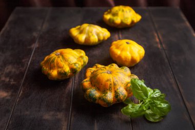 Sarı pastalar ya da kabak ve kahverengi ahşap arka planda fesleğen yaprağı..