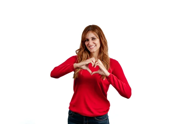 스웨터를 아름다운 여자가 손으로 심장의 동작을 배경에 고립되어 — 스톡 사진