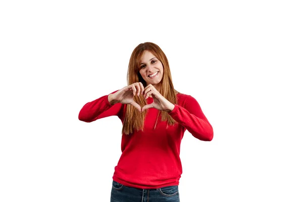 赤いセーターの美しい若い女性は 白い背景に隔離された彼女の手で心のジェスチャーを作ります — ストック写真