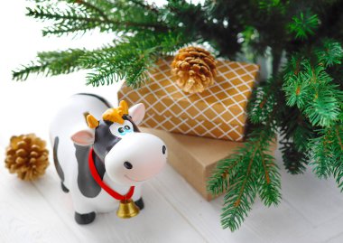 Hediyeli oyuncak boğa, köknar dallarının arka planında. 2021 Çin Yeni Yılı 'nın sembolü, yeni yıl ruh halinin sembolü. Tatil sembolü