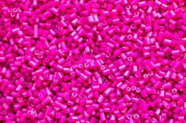 Pembe boncukların arka plan dokusu yakın plan. Kusursuz boncuk dokusu. Hobiler, el yapımı mücevherler, zanaat. Soyut arkaplan