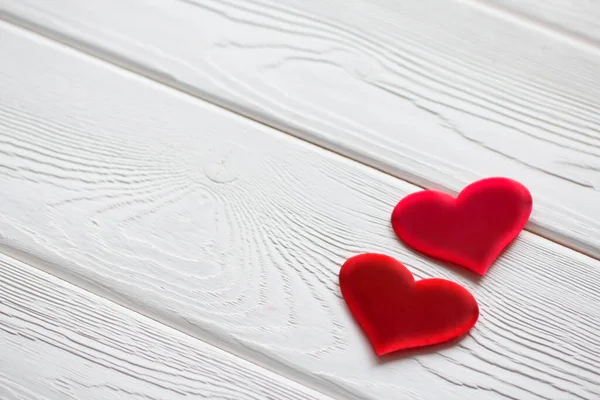 Dos corazones rojos sobre una superficie de madera blanca. Fondo del Día de San Valentín — Foto de Stock