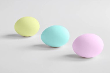 Açık arkaplanlı ve gölgeli pastel renklerde yumurtalar. Minimalizm. Uzayı kopyala Ön manzara. Paskalya Konsepti . 