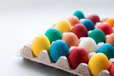 Masadaki karton tepside organik boyalarla boyanmış sarı, kırmızı, turuncu, mavi ve yeşil paskalya yumurtaları. Sıfır ziyan tatili Geleneksel Paskalya. Paskalya konsepti. 