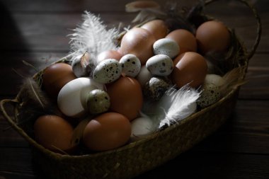 Paskalya israfı. Tavuk ve bıldırcın yumurtaları ahşap bir masada sepetin içinde. Paskalya 'nın sıcak dini bayramı, çevre dostu dekor kavramı. Çiftlik ürünleri