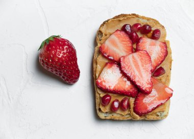 Fıstık ezmeli, çilekli ve nar tohumlu bir sandviç..