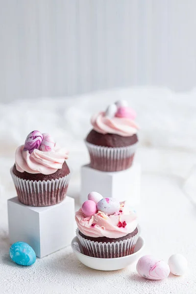 Drei Osterschokolade-Cupcakes mit Karamellfüllung und Dekoration kleiner Ostereier aus Marzipan auf weißem Hintergrund. Selektiver Fokus — Stockfoto