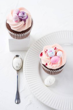 Karamelli iki Paskalya çikolatalı kek ve beyaz porselen tabakta badem ezmesinden küçük Paskalya yumurtaları süslemesi. Seçici odak