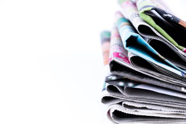 Renkli gazeteleri beyaz arka planda katlanmış ve istiflenmiş olarak kapat