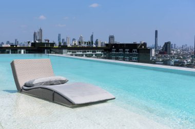 Mavi gökyüzü ve bulutlu yüzme havuzunda dinlenme ya da dinlenme yatağı