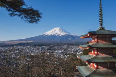 Japonya 'nın Yamanashi ilindeki Arakurayama sengen parkından Fuji Dağı' nın kırmızı Chureito pagoda ve Fujiyoshida şehrinin ikonik görüntüsü..