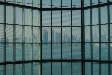 Doha, Katar - 13 Ekim 2019 Doha, Katar 'daki mikrofon eserlerinden biri olan İslam Sanatları Müzesi' nin cam penceresinden şehrin gölge görüntüsü. Ada 'nın en eksiksiz koleksiyonlarından biri.