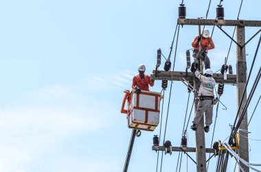 Samut Sakhon, Tayland - Haziran 2019: Elektrikçiler elektrik hatlarını kurmak ve onarmak için elektrik direklerine tırmanıyorlar. 23 Haziran 2019 'da Samut Sakhon, Tayland' da.