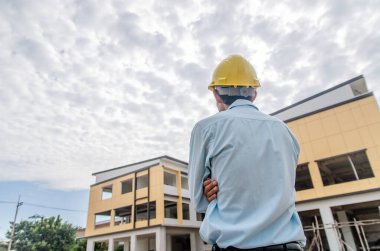 İnşaat mühendisi inşaat alanında duruyor.