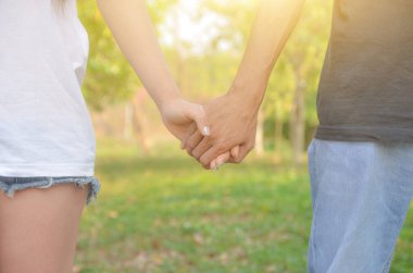 El ele tutuşan çiftler bahçede yürüyor ve dinleniyorlar.