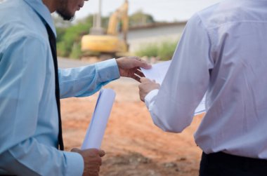 İnşaat mühendisi inşaat alanındaki bir konuşmada duruyor.