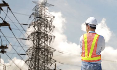 Elektrik kulesini izleyen elektrik teknisyeni.