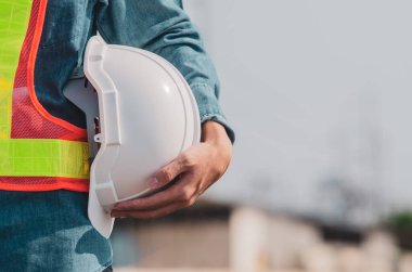 Beyaz güvenlik kaskı bir mühendisin elinde..