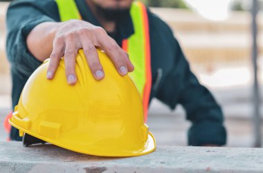 Bir inşaatçının ellerinde sarı güvenlik kaskı