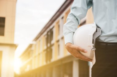 Bir inşaat işadamının ellerinde beyaz başlık.