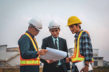 İnşaat alanında fabrika geçmişi olan bir mühendis ve işçi planının görüntülenmesi.