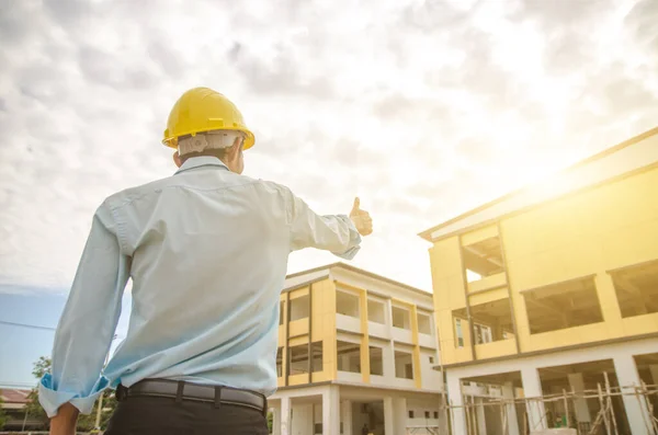 construction engineer stood with a thumbs-up after the building inspection.