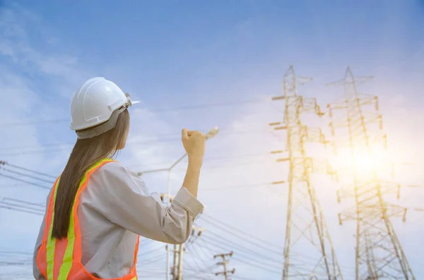 Successful Female Engineer Stands High Voltage Electricity Pole ロイヤリティフリーのストック画像