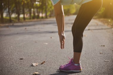 Parkta spor yaptıktan sonra gerinen kadınların el pençe divan duruşu ve sabah güneşin doğuşu.