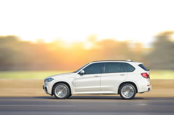 motion photos, white car running on the road with the sunset background