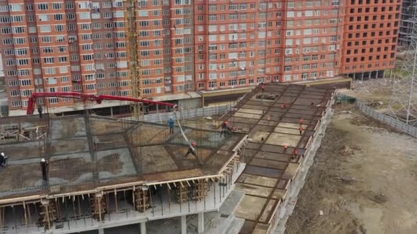Construction workers deliver liquid concrete to upper floor — Stock Video