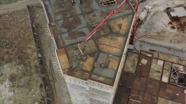 Workers cover upper floor mesh with concrete using pump — Stock Video