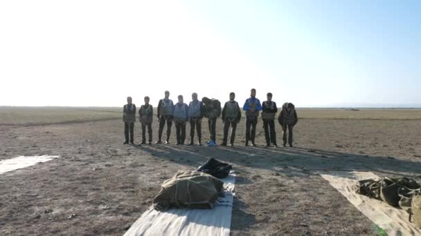 Parachutists group in special equipment stands among field — Stock Video