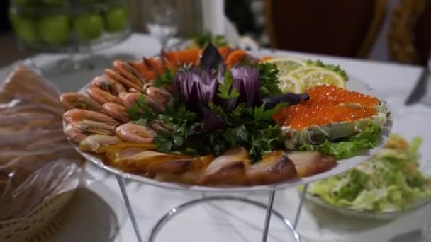 Teller mit Garnelen, rotem Fisch und Kaviar auf festlichem Tisch — Stockvideo