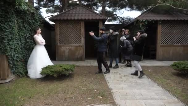 Фотографи фотографують наречену на подвір'ї ресторану — стокове відео
