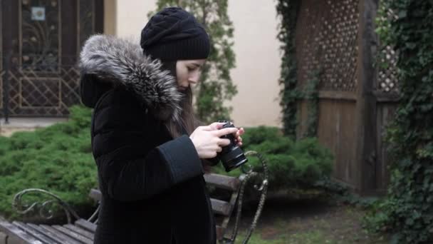Γυναίκα κοιτάζει φωτογραφία στην οθόνη της κάμερας στέκεται στον κήπο — Αρχείο Βίντεο