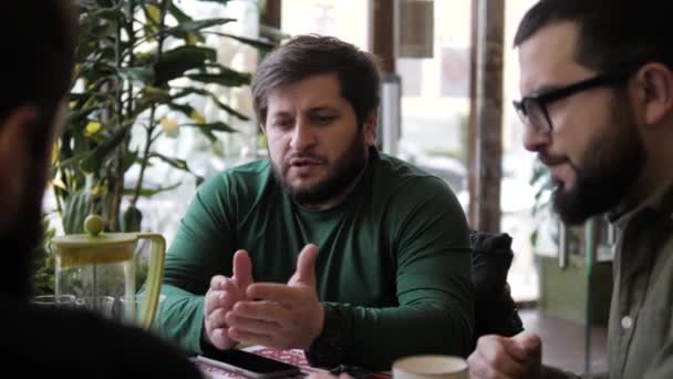 Barbudo hombre pasa tiempo con amigos en el restaurante — Vídeos de Stock