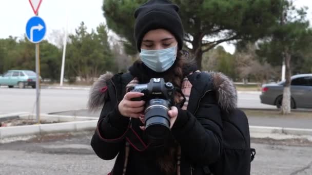 医療マスクの女性が路上で立って写真を撮る — ストック動画