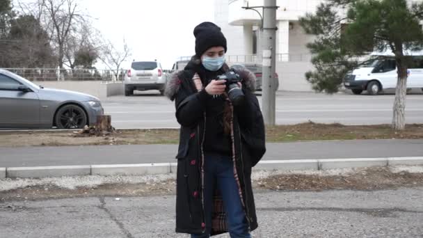 マスクの女性は路上で同僚の近くに立って写真を撮る — ストック動画