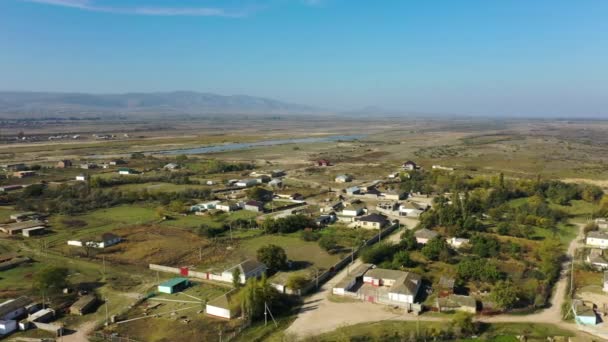 Tranquilo pueblo con pequeños edificios en el valle en el día soleado — Vídeos de Stock