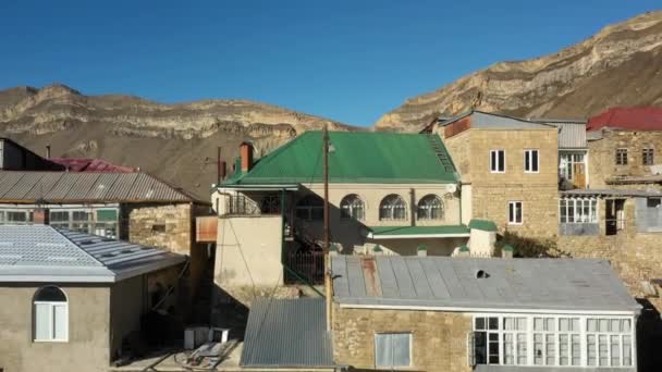 Edificio con ventanas de arco y techo verde en el pueblo de Chokh — Vídeo de stock