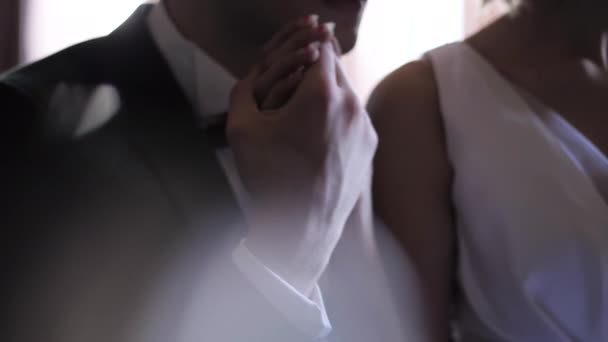 Zorgvuldige bruidegom houdt bruid hand zitten samen in donkere kamer — Stockvideo