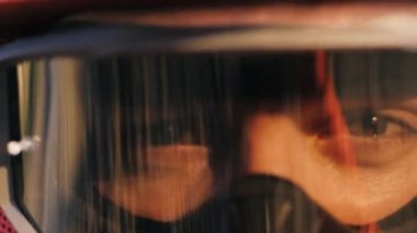 Özel maske takan yeşil gözlü bisikletçi kameraya bakıyor.