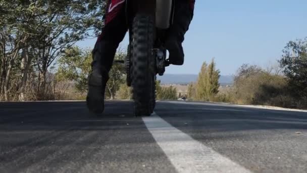 Motociclista con traje protector a lo largo de la carretera de asfalto — Vídeo de stock