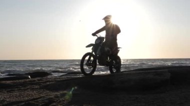 Koruyucu miğferli motorcu silueti hızla kameranın önünden geçiyor.