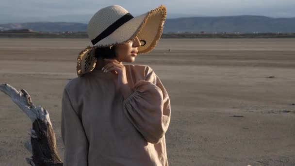 Hübsches Model mit breitem Strohhut und beigem Kleid posiert — Stockvideo