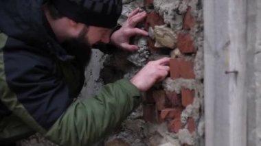 Sakallı adam ve yeşil, uyuşturucu dolu plastik torba alıyor.